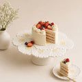 Decorative cake stand with a cake and berries on a light background