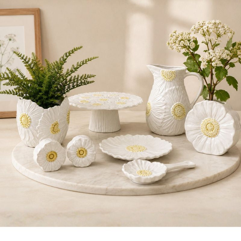 White ceramic tableware set with floral patterns on a marble surface.