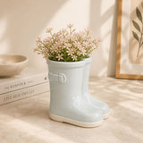 Sage green boot planter with flowers in minimalist home decor