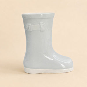 Light blue rain boot on a beige background