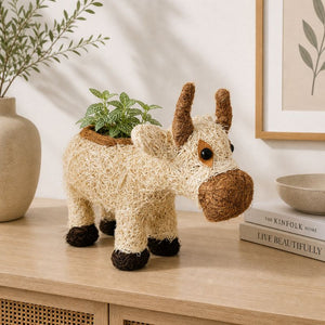 Cow planter with plant styled on minimalist shelf with neutral decor