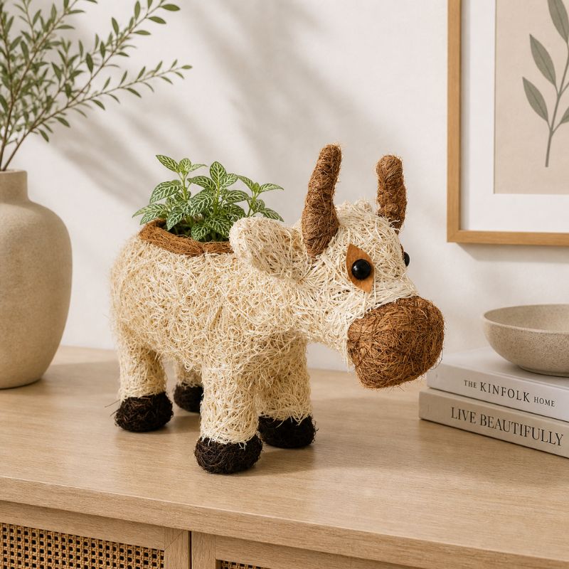 Cow planter with plant styled on minimalist shelf with neutral decor