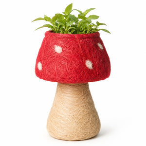A HUSK Toadstool Planter – Red & White 19cm made from red and beige yarn, with a green potted plant inside, photographed on a clean white background.