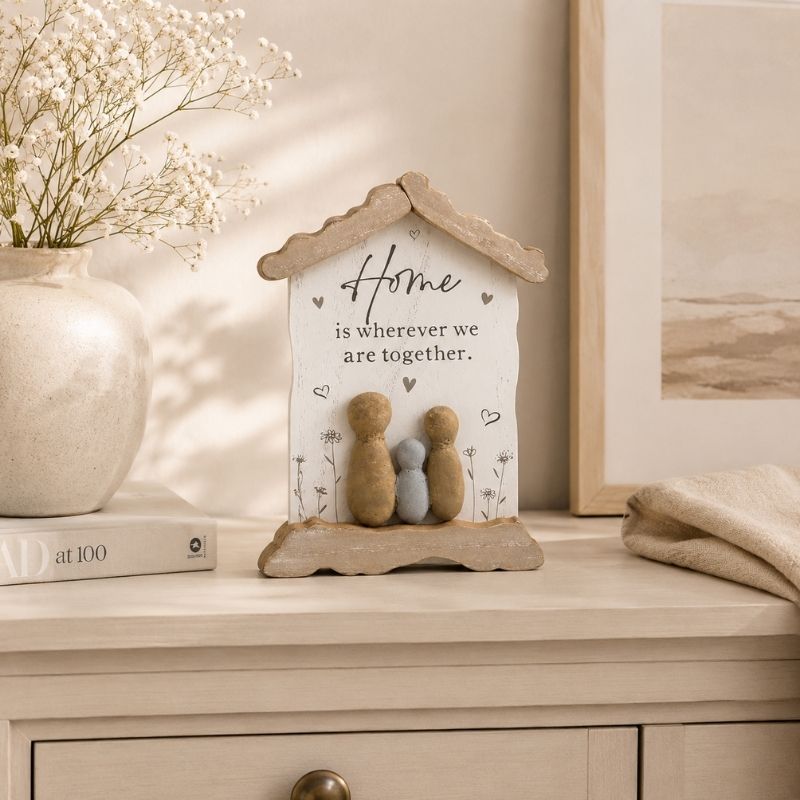 Home hanging plaque displayed on a beige console table with ceramic vase and neutral home decor accents in a modern farmhouse setting.