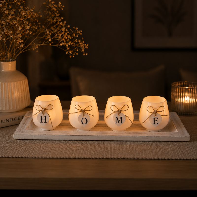 Decorative HOME candle holder tray with lit candles styled on a console table with elegant lighting and cozy home accents.