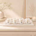 HOME ceramic candle holder set on a white decorative tray styled on a beige console table with minimalist home décor accents.