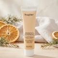 Tube of huxter Orange & Cedarwood hand cream with decorative elements on a neutral background