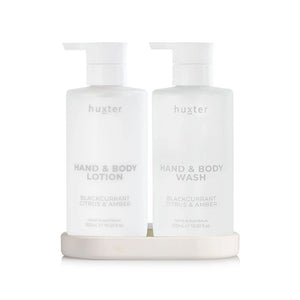 Two bottles of huxter hand and body products on a white background