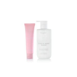 Pink tube and white bottle of Huxter hand and body wash on a white background
