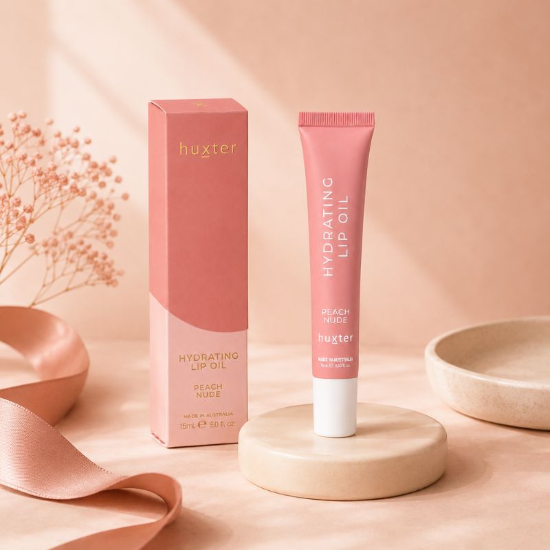 Huxter Peach Nude Lip Oil with matching box in blush pink studio setting