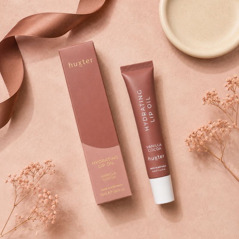 Huxter Vanilla Cocoa Hydrating Lip Oil and matching box in blush pink overhead flat lay