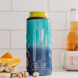 Blue thermos with 'Love Your Travels' text on a kitchen counter with oranges and nuts.