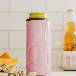 Pink insulated bottle holder on a kitchen counter with oranges and nuts.