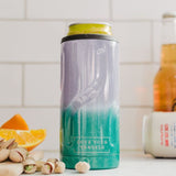 Tall cylindrical container with gradient design and text, placed on a surface with oranges and nuts.