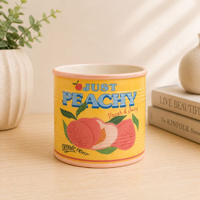 Yellow container with 'Just Peachy' text and peach illustrations on a wooden surface.