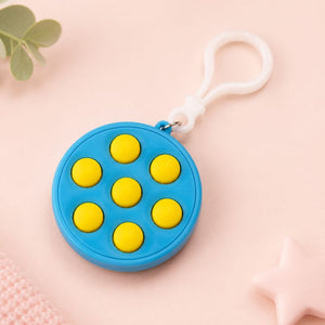 Blue fidget toy with yellow dots and a white clip on a pink background