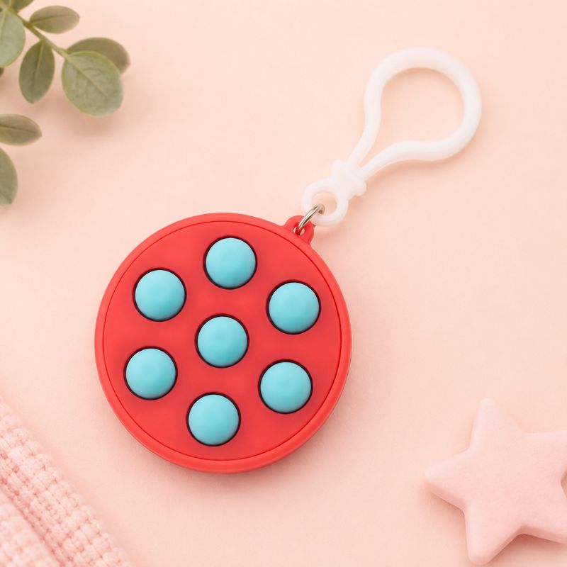 Pink fidget toy with blue buttons on a pink background