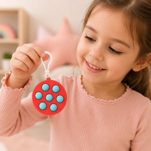 Child holding a pink fidget toy with blue buttons in a cozy indoor setting