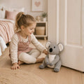 Child holding a plush koala toy door stopper in a cozy room.