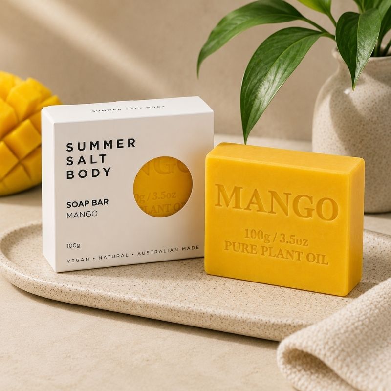 Mango Soap Bar - 100g and packaging labeled 'Summer Salt Body' on a beige surface with a plant in the background.