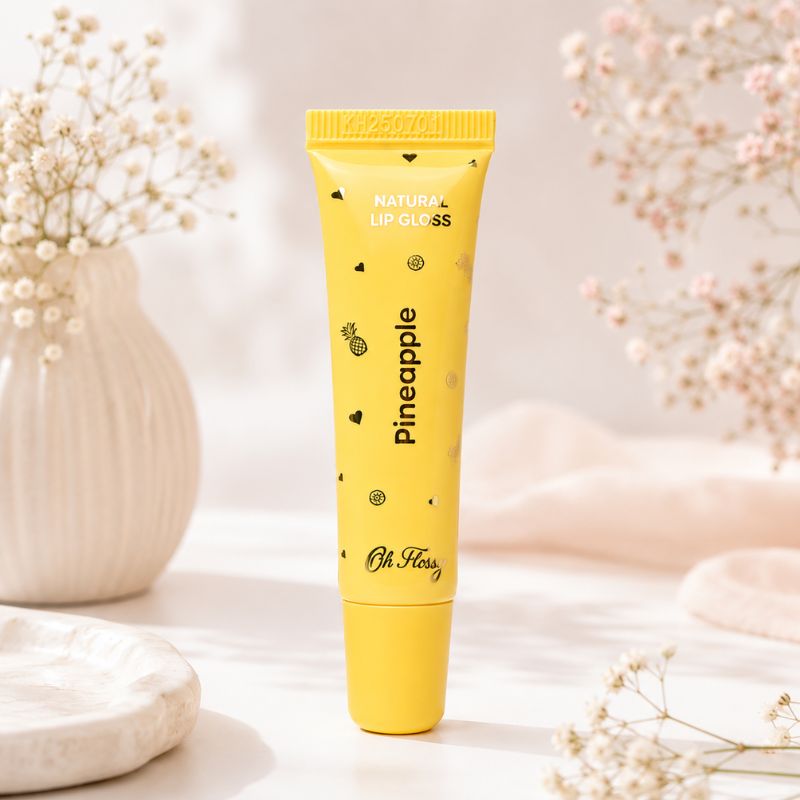 Oh Flossy Pineapple Natural Lip Gloss tube on a soft aesthetic background