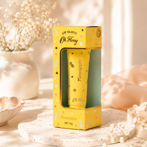 Oh Flossy Pineapple Lip Gloss for Kids displayed in yellow packaging with floral decor