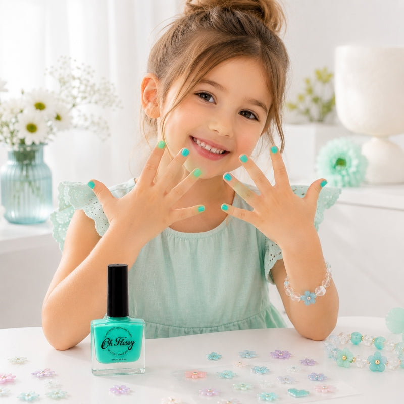 Young girl showing aqua painted nails with Oh Flossy Kids Nail Polish