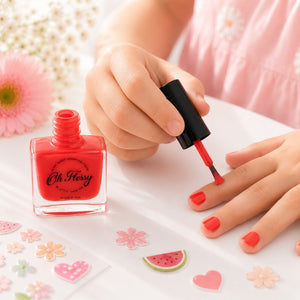 Close-up of watermelon red Oh Flossy Kids Nail Polish being applied to a child’s nail