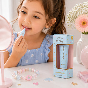 Young girl applying Oh Flossy Cotton Candy natural lip gloss for kids