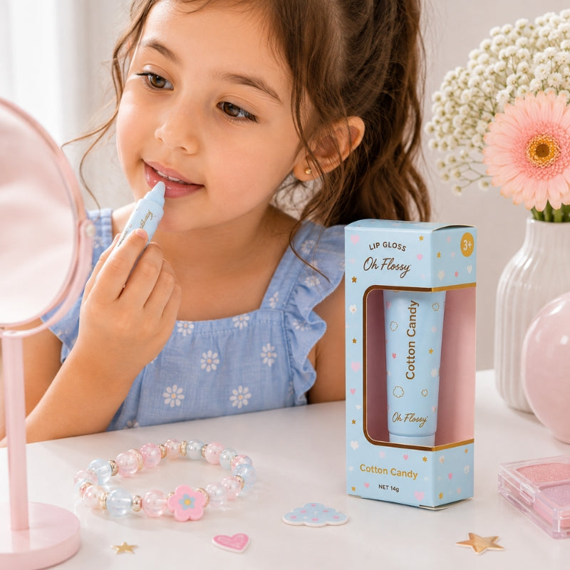 Young girl applying Oh Flossy Cotton Candy natural lip gloss for kids