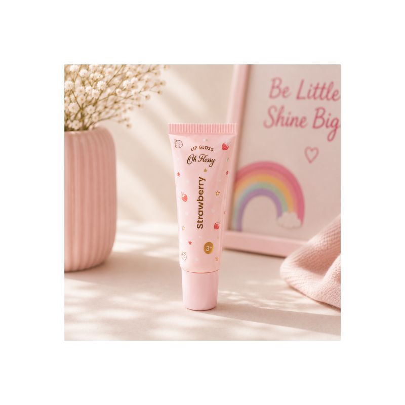 Oh Flossy Strawberry kids lip gloss tube displayed in a soft pink aesthetic setting