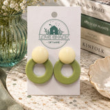Olive Grove Dangle Earrings on a 'Love Shack Giftware' card with books in the background.