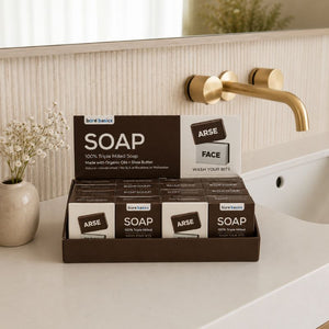 Display of bare basics soap bars on a bathroom counter with a gold faucet in the background.