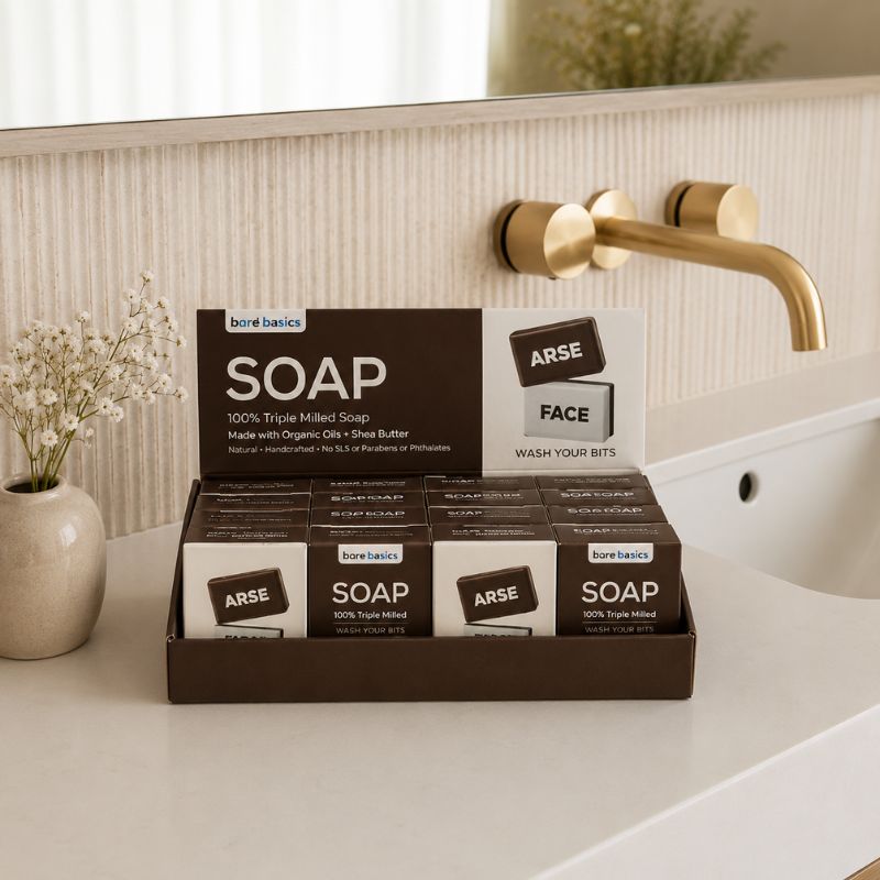 Display of bare basics soap bars on a bathroom counter with a gold faucet in the background.