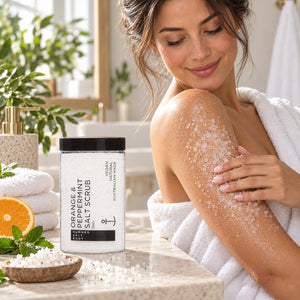 Woman applying Orange and Peppermint Salt Scrub to her arm in a spa-inspired bathroom
