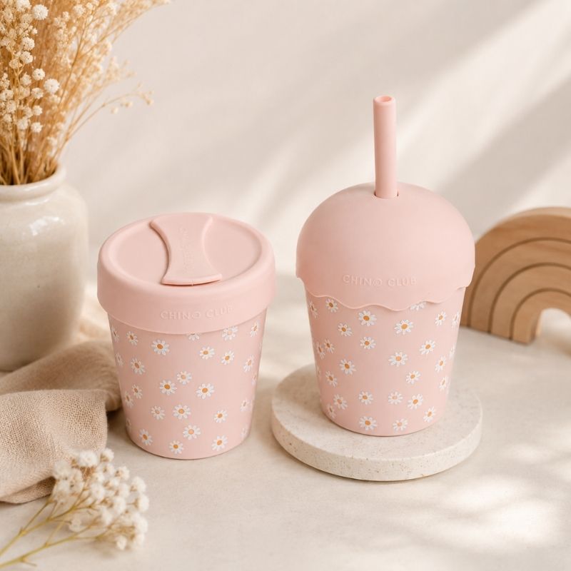 Two Pink Daisy Mini Smoothie Cup & Straw 200ml on a light surface with decorative elements.