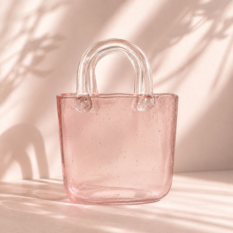 Pink glass tote bag with clear handles on a soft pink background