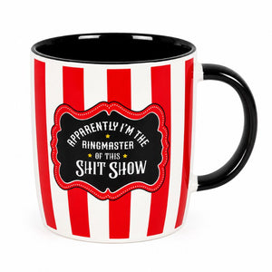 A ceramic mug with red and white vertical stripes, a black interior and handle, and a black label on the front that reads, 'APPRORENTLY I'M THE RINGMASTER OF THIS SHIT SHOW'.