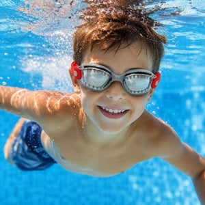 Child swimming underwater wearing Shark Grey JAWS swim goggles in a clear blue swimming pool