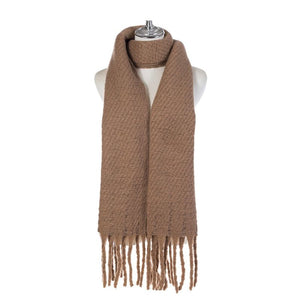 A sand chunky knit winter scarf with Fringe in a warm camel brown color, draped on a white mannequin torso with a silver neck cap, set against a plain white background.