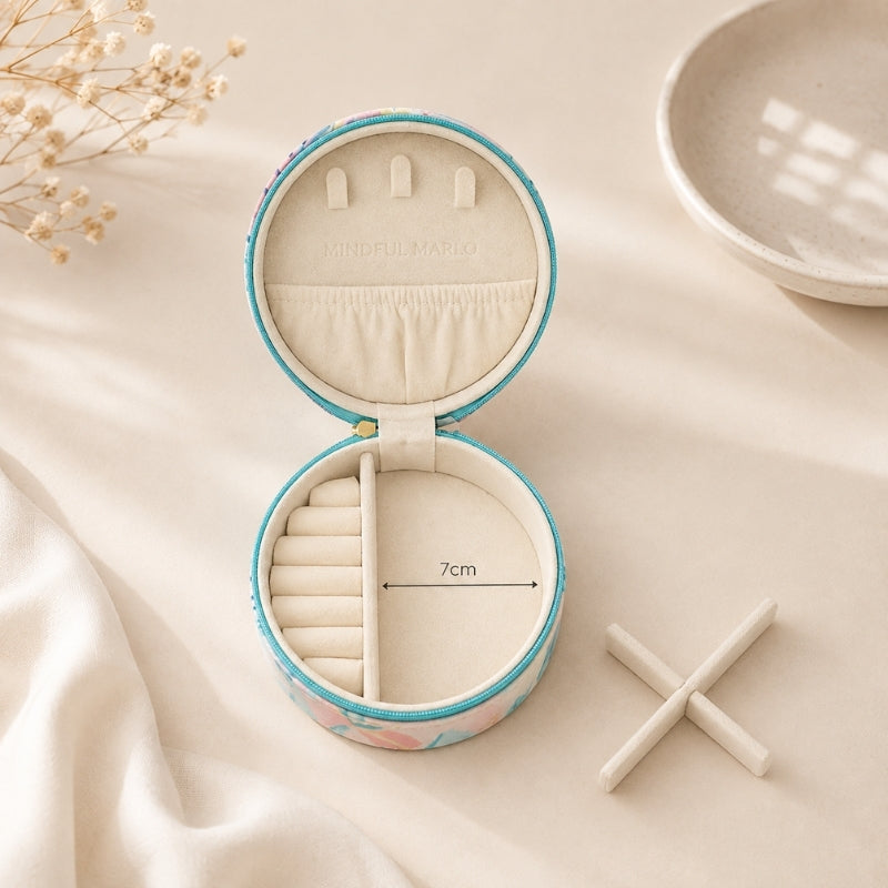 A Small Jewellery Case – Haven with a pastel floral pattern and turquoise trim, shown on a soft cream fabric background. The inside has cream fabric lining with ring rolls and a divider, plus a printed measurement marker reading 7cm.