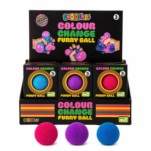 A retail display box of Moodys Colour Change Furry Ball toys, showing three individual balls in pink, purple, and blue, with the black display packaging behind them on a white background.