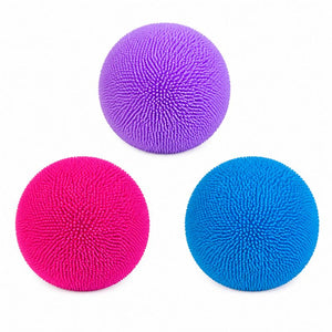 Three textured stress balls in purple, pink, and blue, arranged in a triangle on a white background.