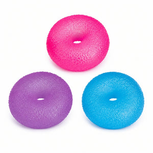 Smoosho's Super Squeeze Glow-in-the-Dark Doughnut exercise or massage balls in bright pink, purple, and blue, arranged on a plain white background.