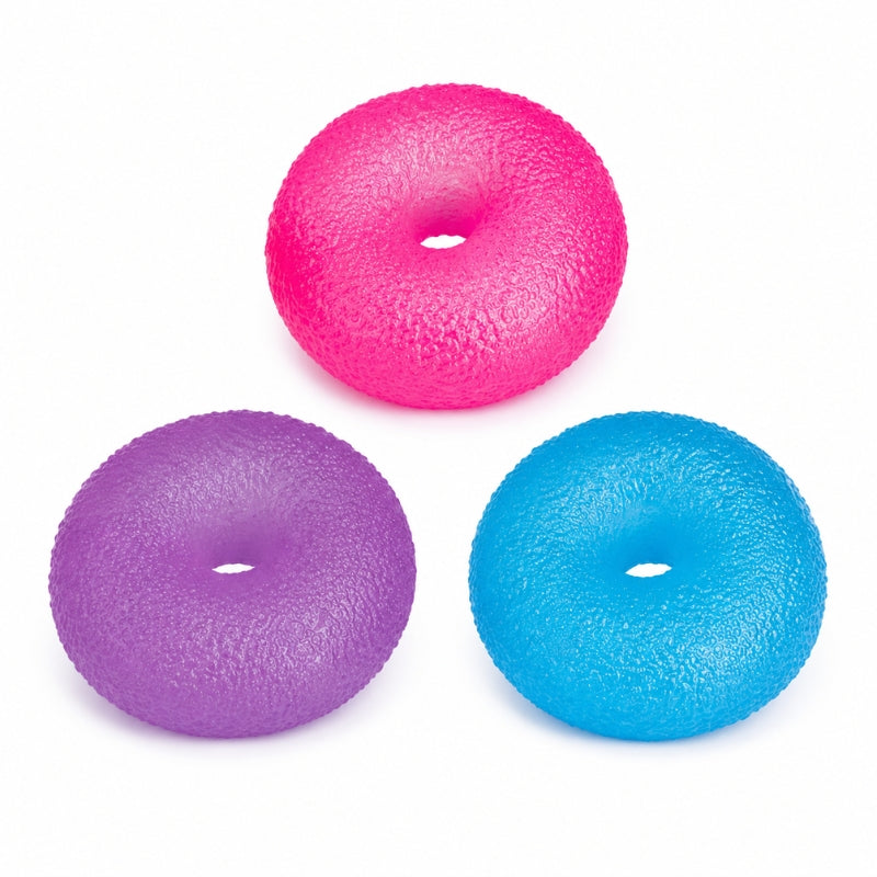 Smoosho's Super Squeeze Glow-in-the-Dark Doughnut exercise or massage balls in bright pink, purple, and blue, arranged on a plain white background.