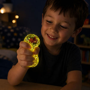 Child playing with a glowing Smooshos Super Squeeze Diamond Sphere Dino squishy toy at night