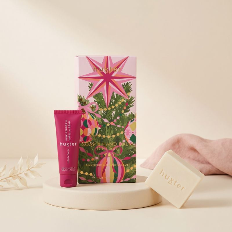 Huxter Soap and Hand Balm Gift Set styled on a soft blush surface with hand balm tube and cream soap