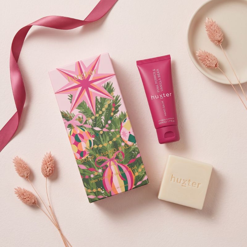 Overhead flat lay of Huxter Soap and Hand Balm Gift Set with pink hand balm tube and cream soap bar