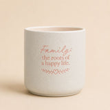 Splosh ceramic planter with “Family the roots of a happy life” quote on beige background