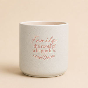 Splosh ceramic planter with “Family the roots of a happy life” quote on beige background